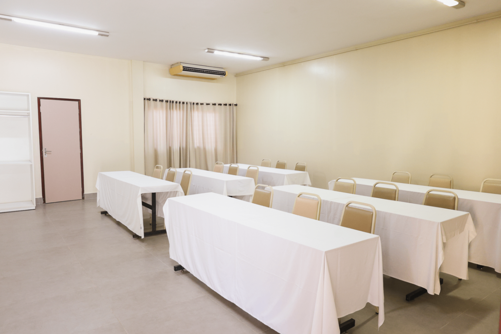 Sala de apoio em formato escola com mesas retangulares e cadeiras