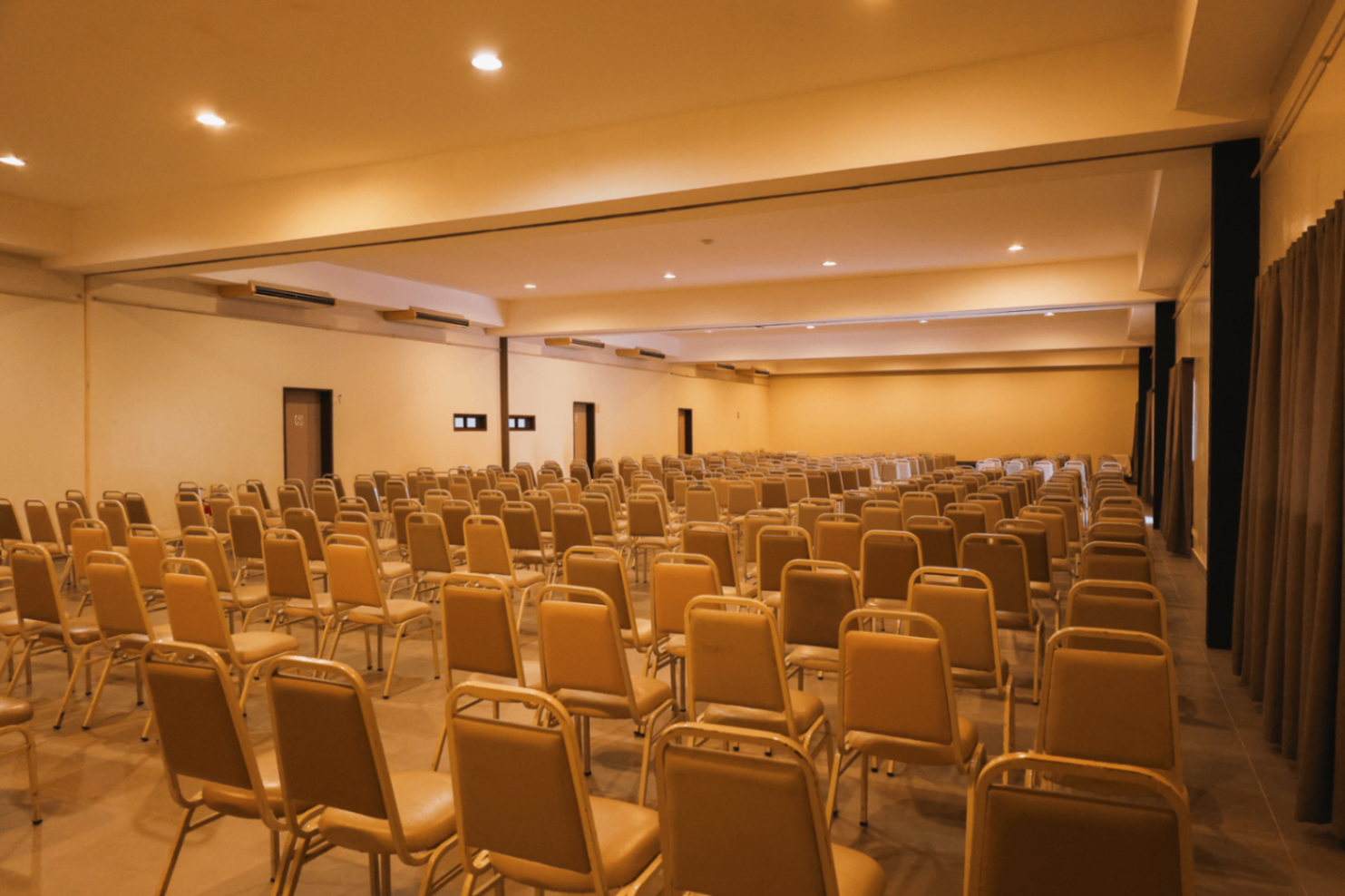 Auditório com divisórias e cadeiras organizadas para evento corporativo